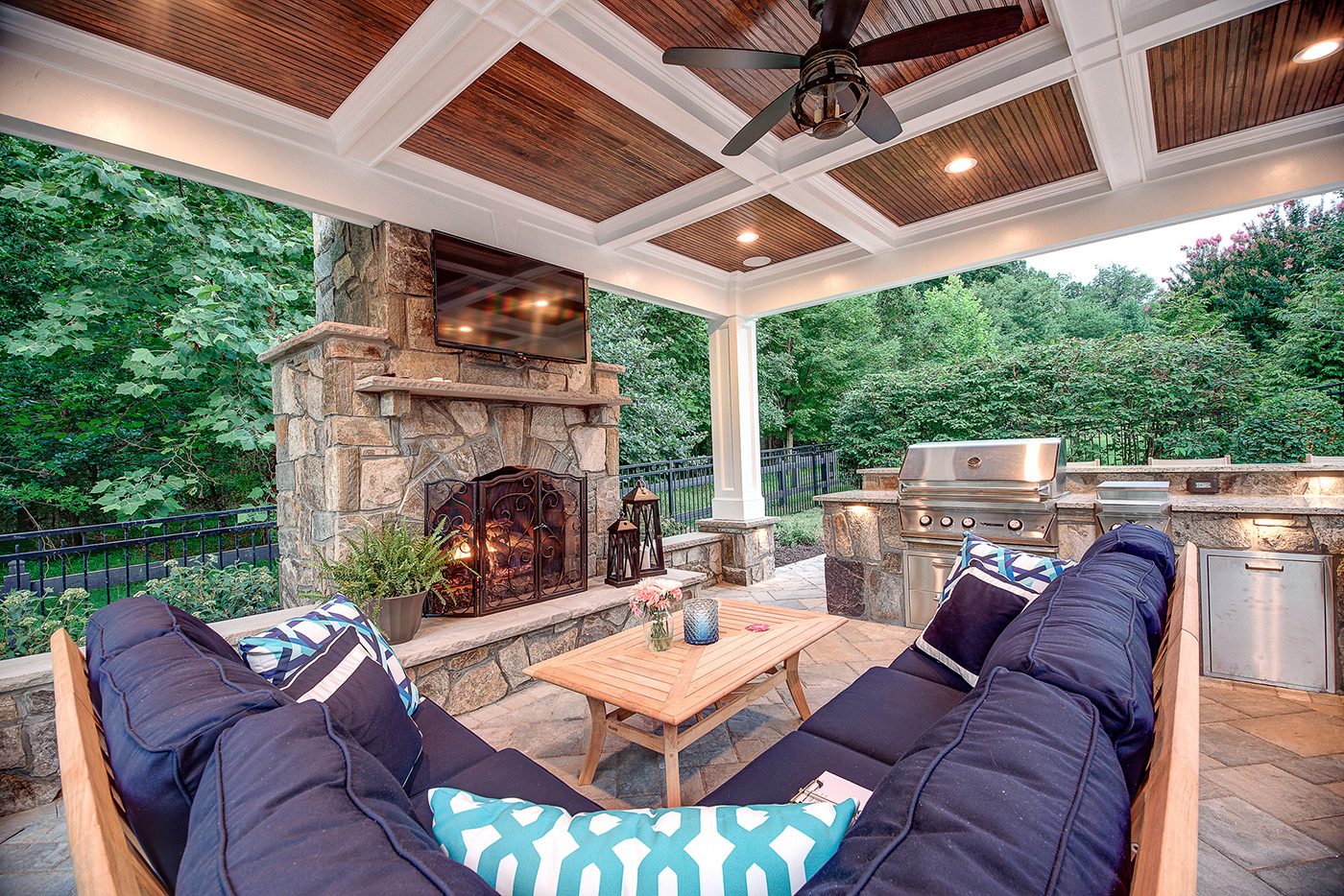 Covered patio with stone fireplace and outdoor kitchen