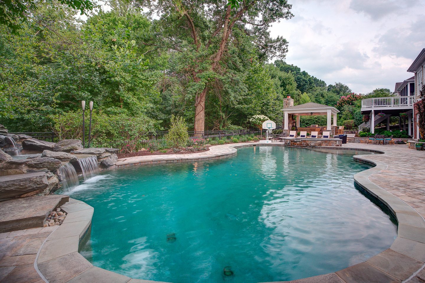 Free-form pool with a natural stone waterfall and landscaped garden