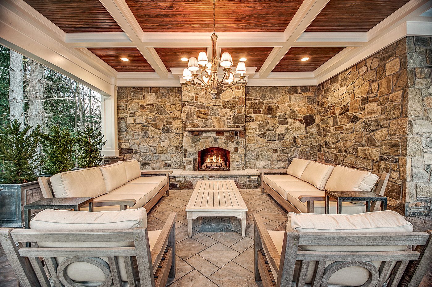 Outdoor seating area with stone fireplace and wooden beam ceiling