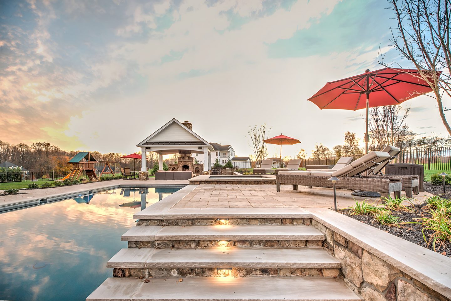 Pool and patio area with a covered pavilion featuring a fireplace