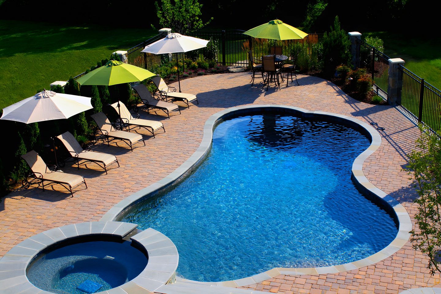 Pool on brick deck with umbrellas