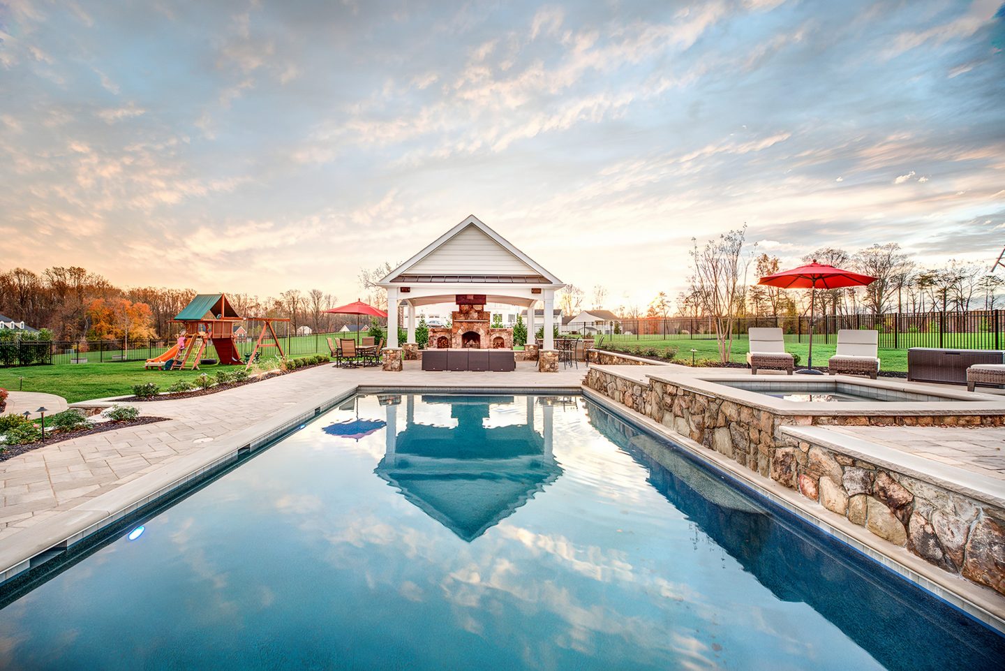 Pool in a residential backyard with a stone patio