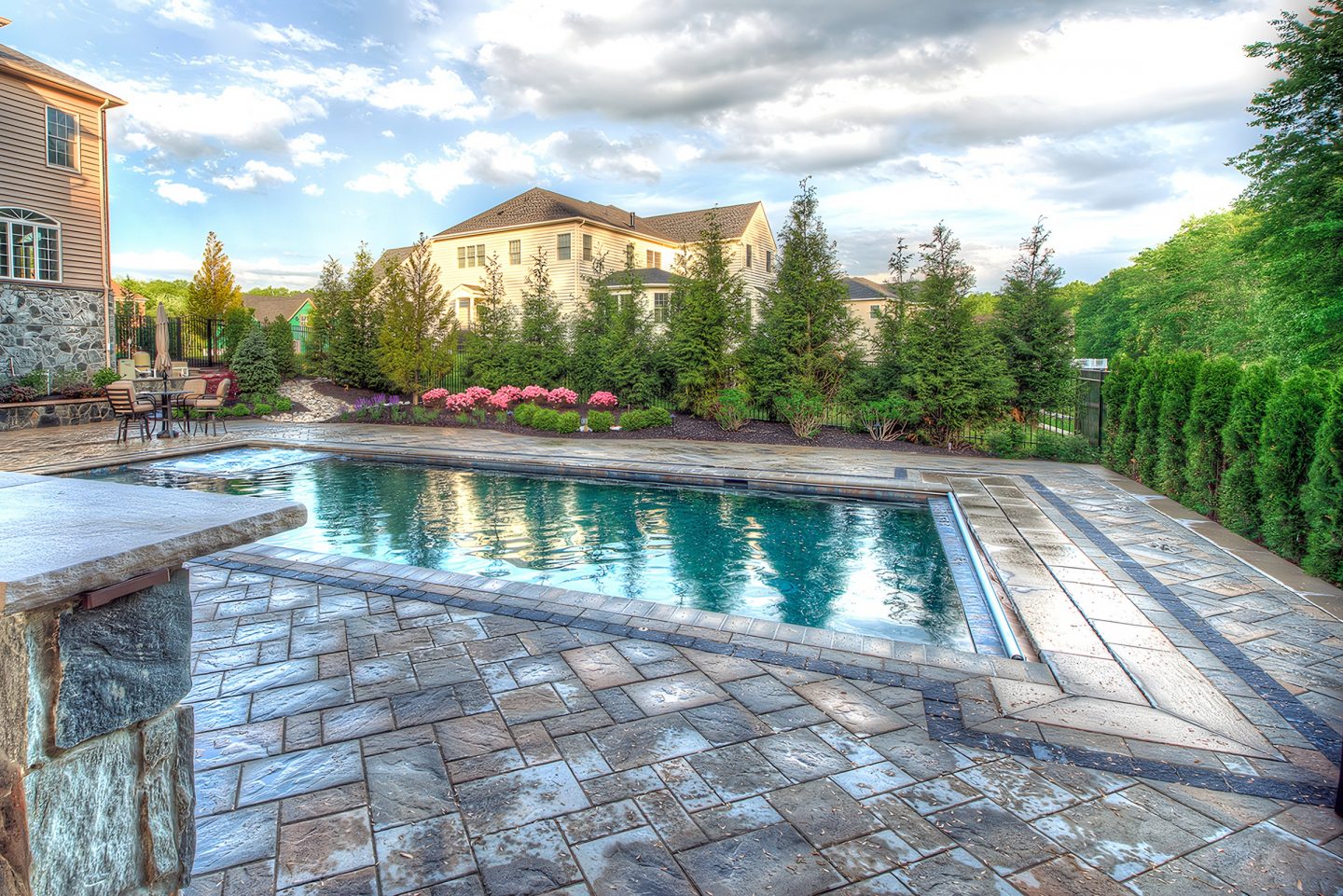 Paved patio and swimming pool in residential backyard