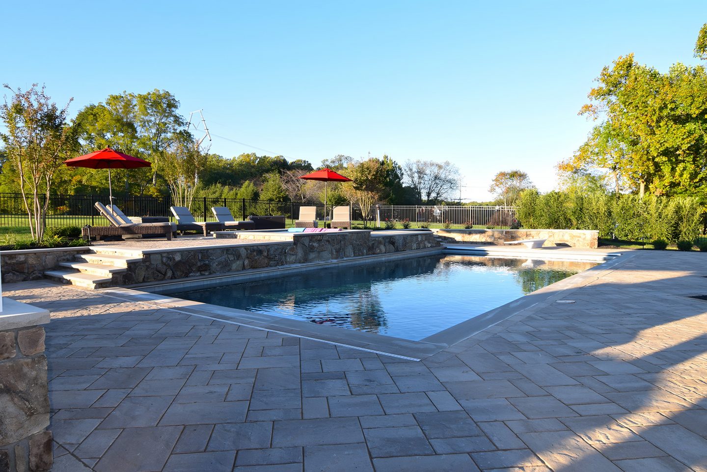 Pool on patio with stone retaining wall